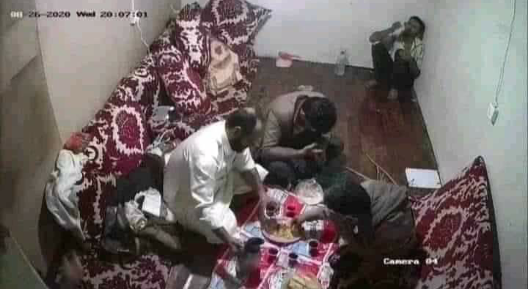 صورة الضحية عبدالله الأغبري يتألم، و الجناة يتناولون الطعام